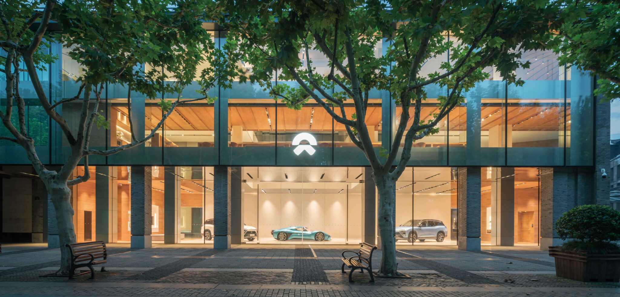 A Nio electric SUV in a dealership showroom with the brand's angular lighting design.